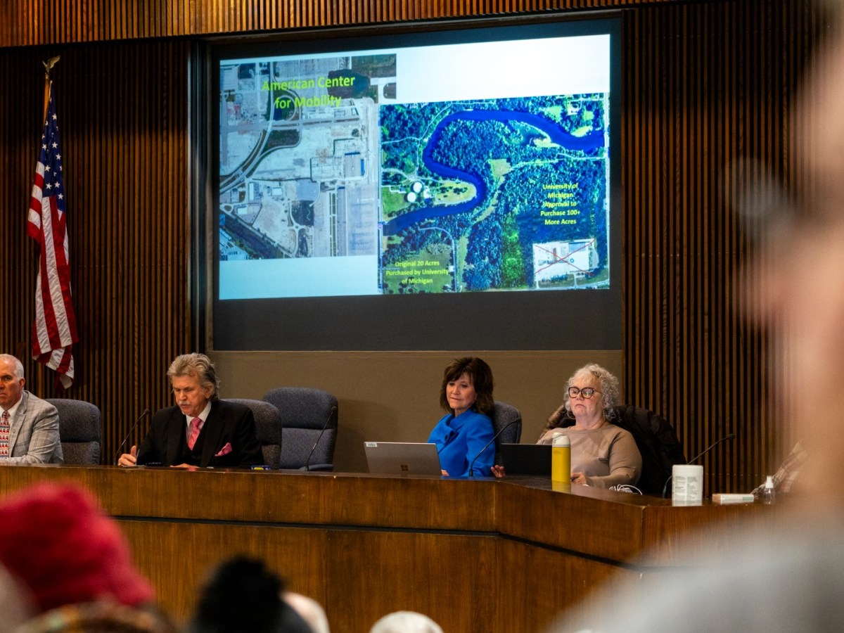 People listen at a town hall meeting