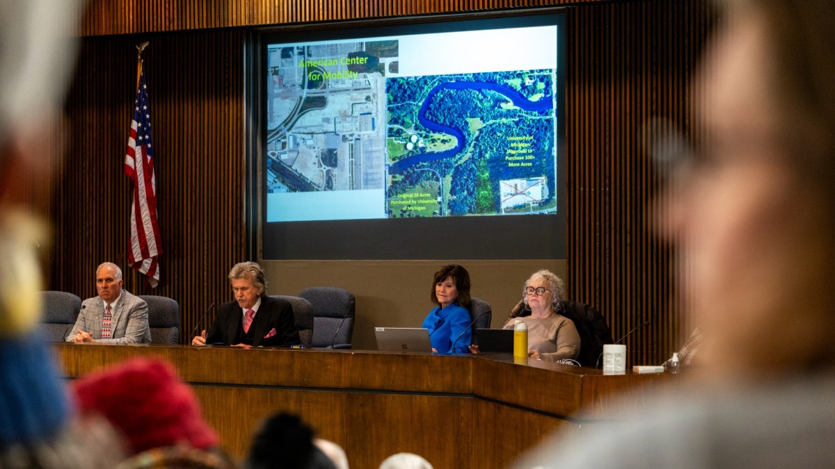 People listen at a town hall meeting
