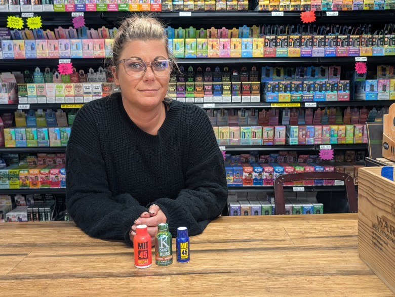 A woman poses behind the counter in a store 