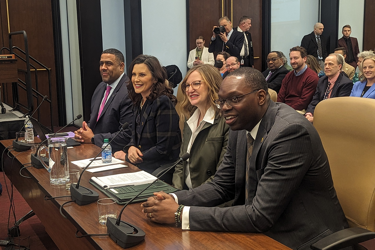 Gov. Gretchen Whitmer sits at a table with other state officials.