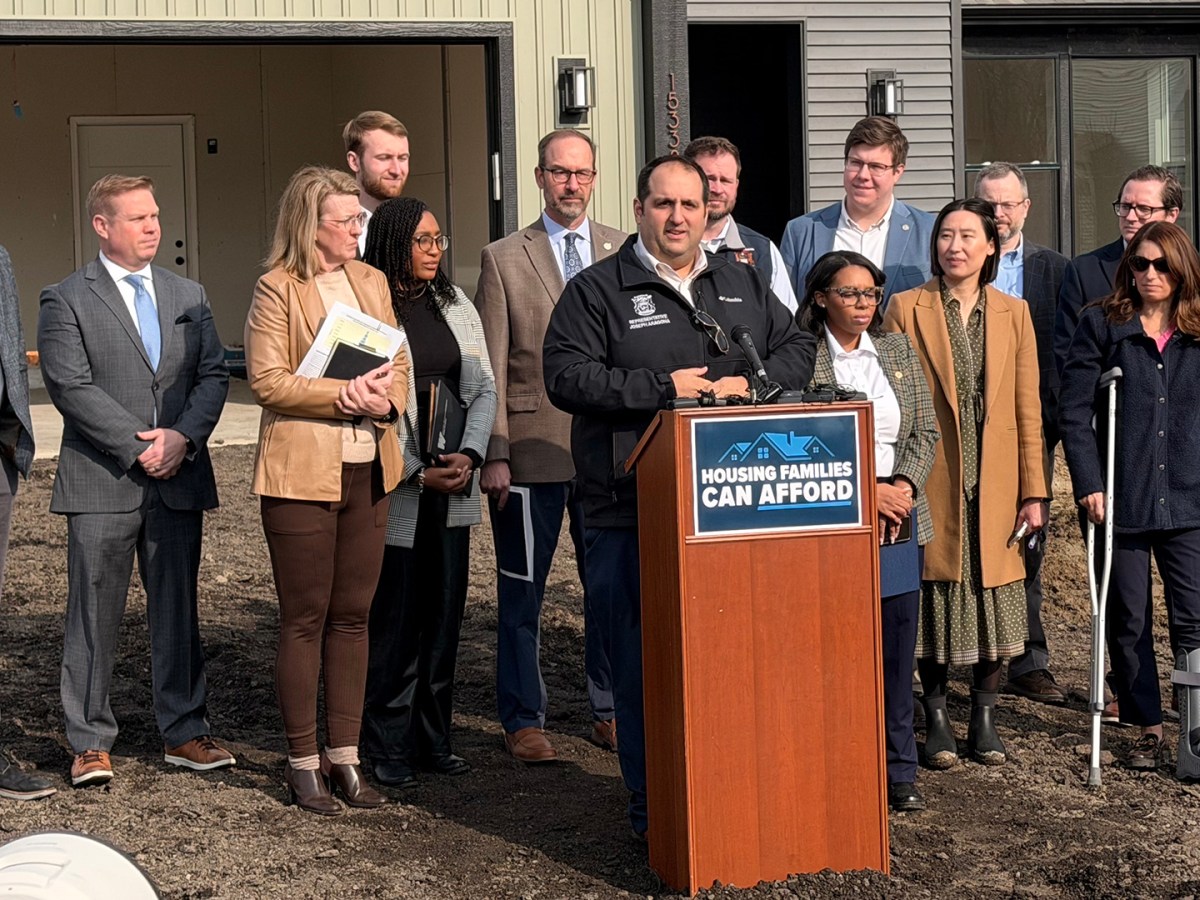 Lawmakers in front of a house in a press conference.