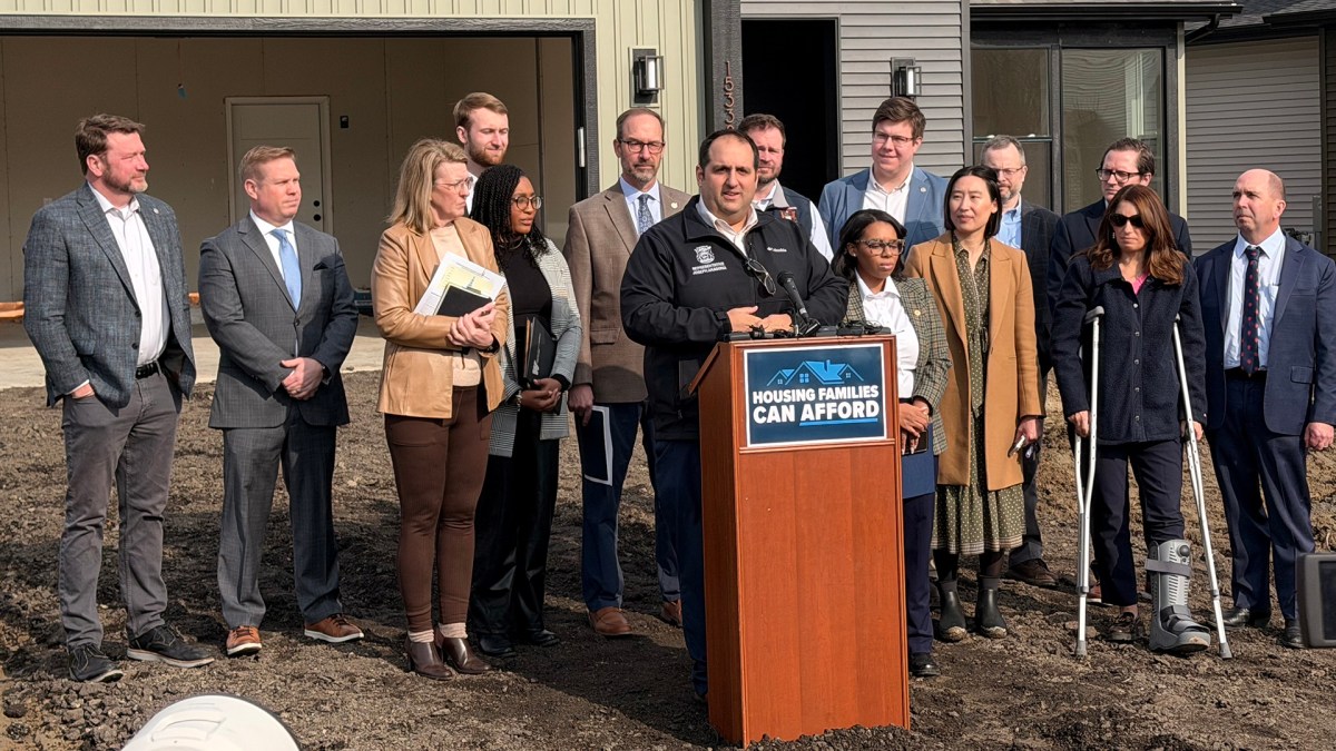 Lawmakers in front of a house in a press conference.