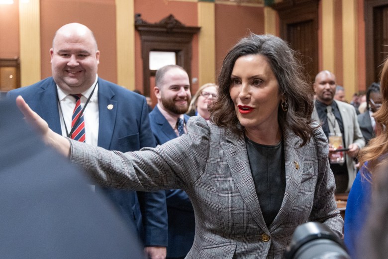 Gov. Gretchen Whitmer  walks past lawmakers. 
