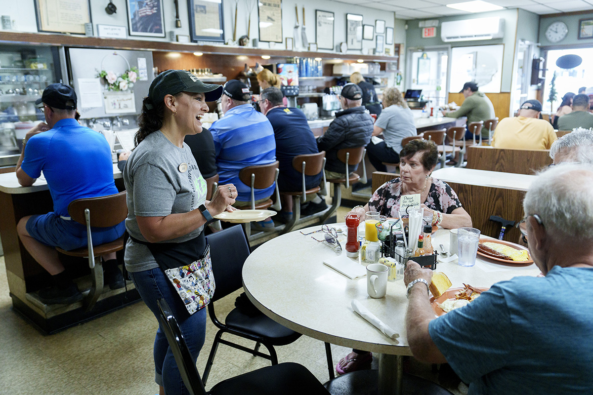 Jody hunter, of Grayling serves food to Renita, Denise, and Butch, Clements from Santa Barbara, California at the Grayling Restaurant in Grayling, Mich.