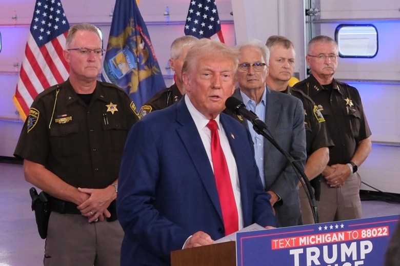 President Donald Trump stands next to law enforcement at a campaign stop.