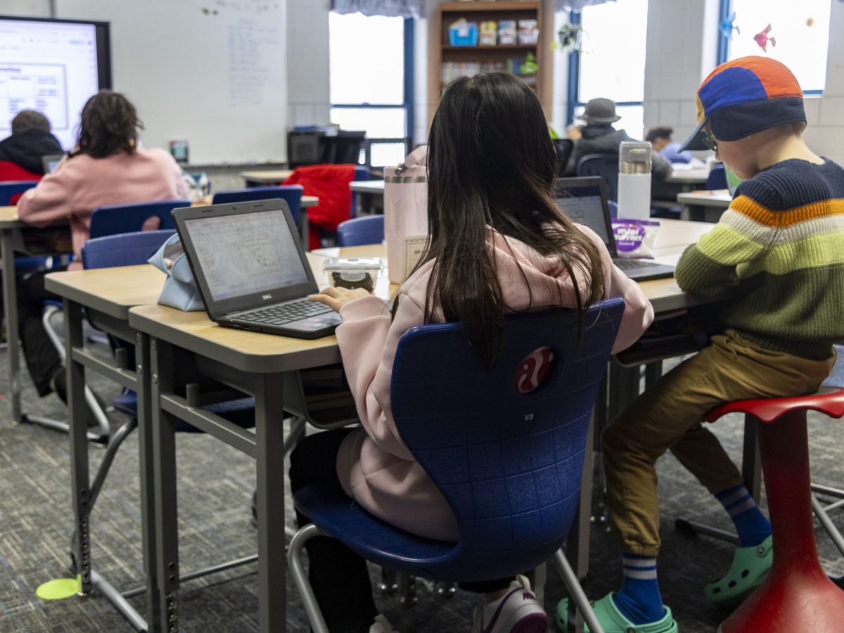 Children are working at their desks in a classroom.