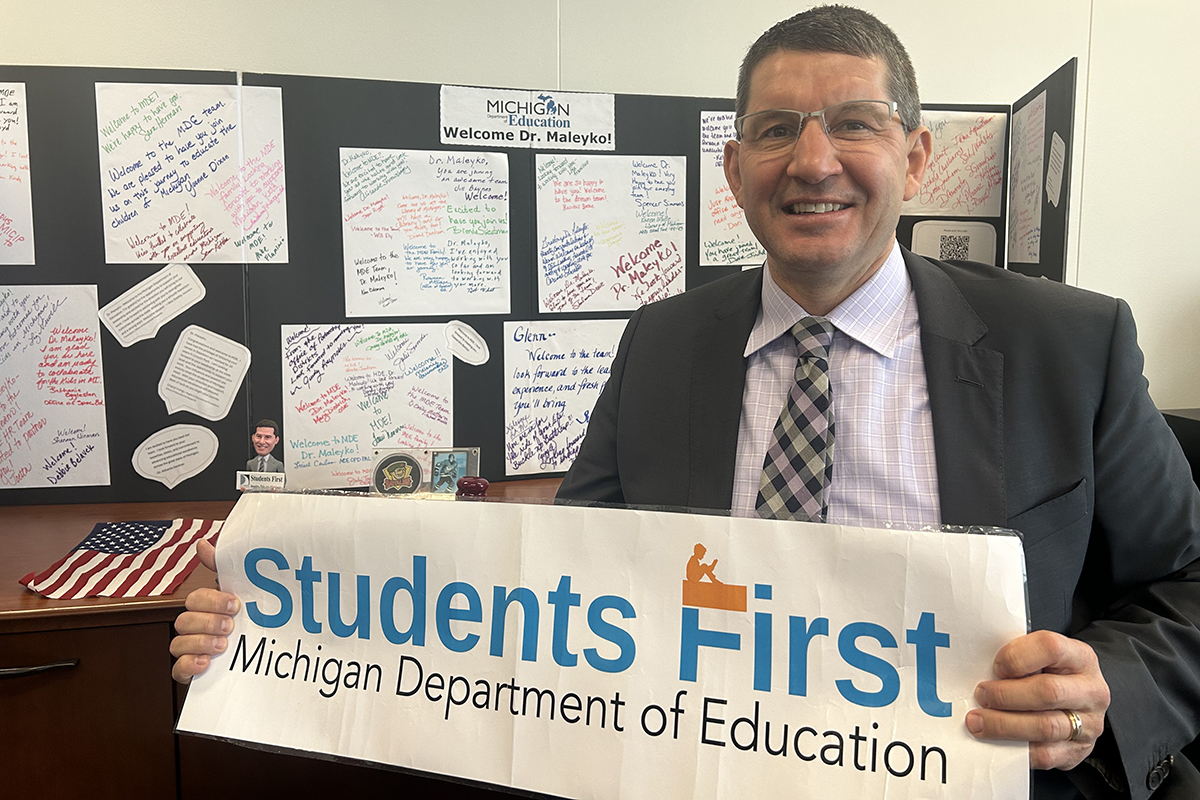 State Superintendent Glenn Maleyko holds a sign that says "Students First."