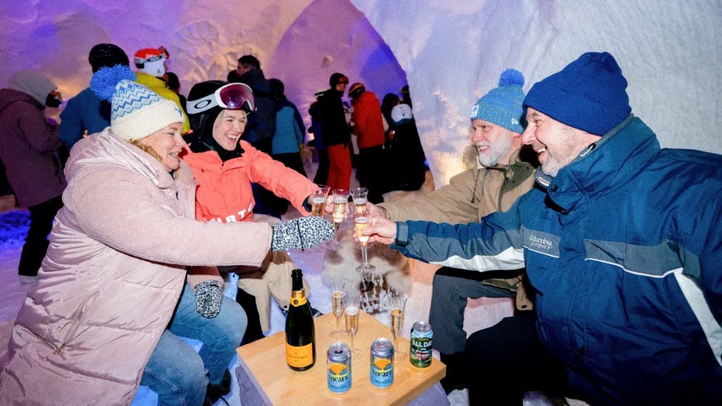 People sit inside an igloo bar and drink