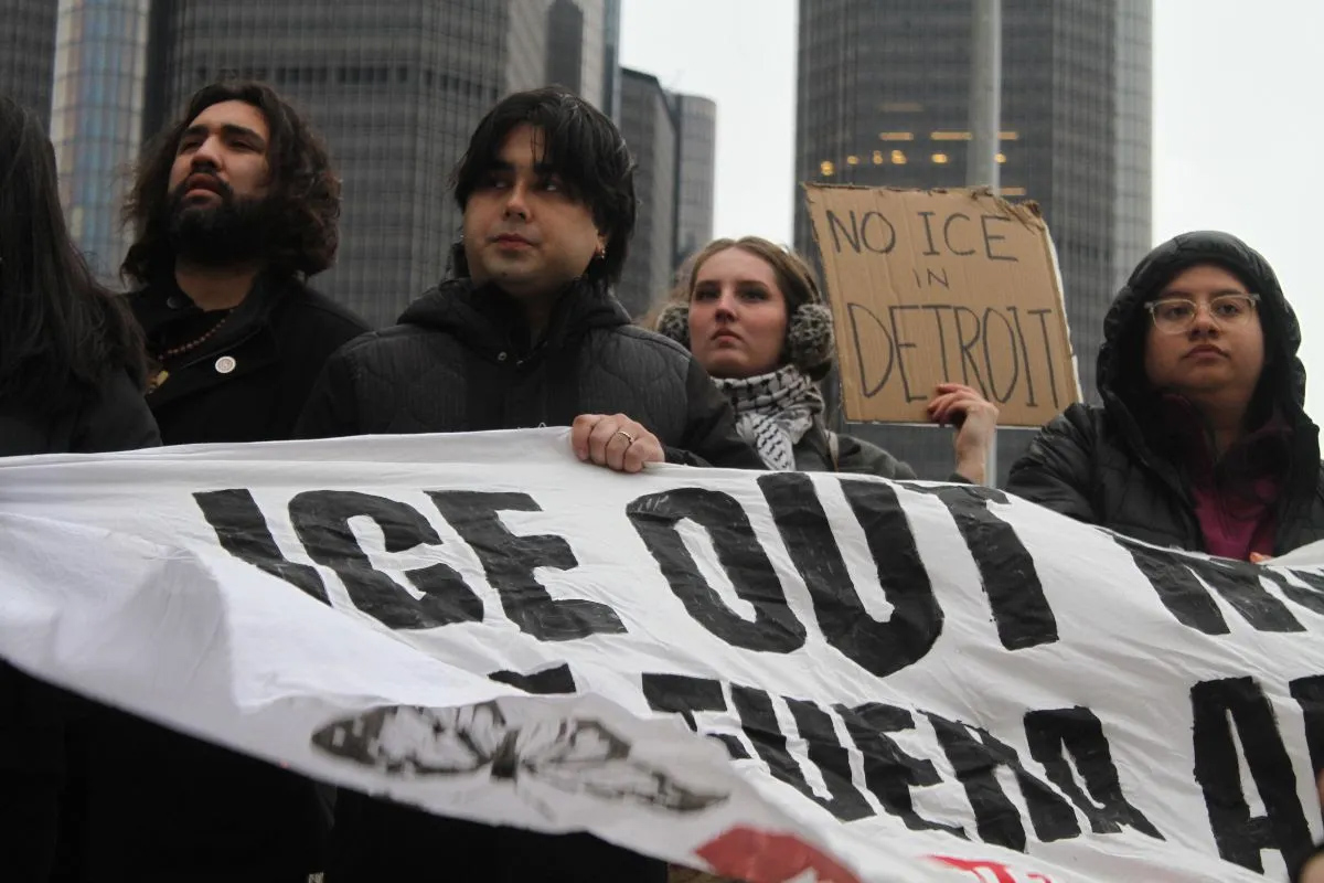 People marching in Detroit, holding anti-ICE signs.