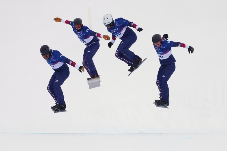 Four people snowboarding. 