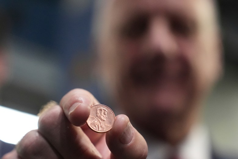 A man holding a penny.