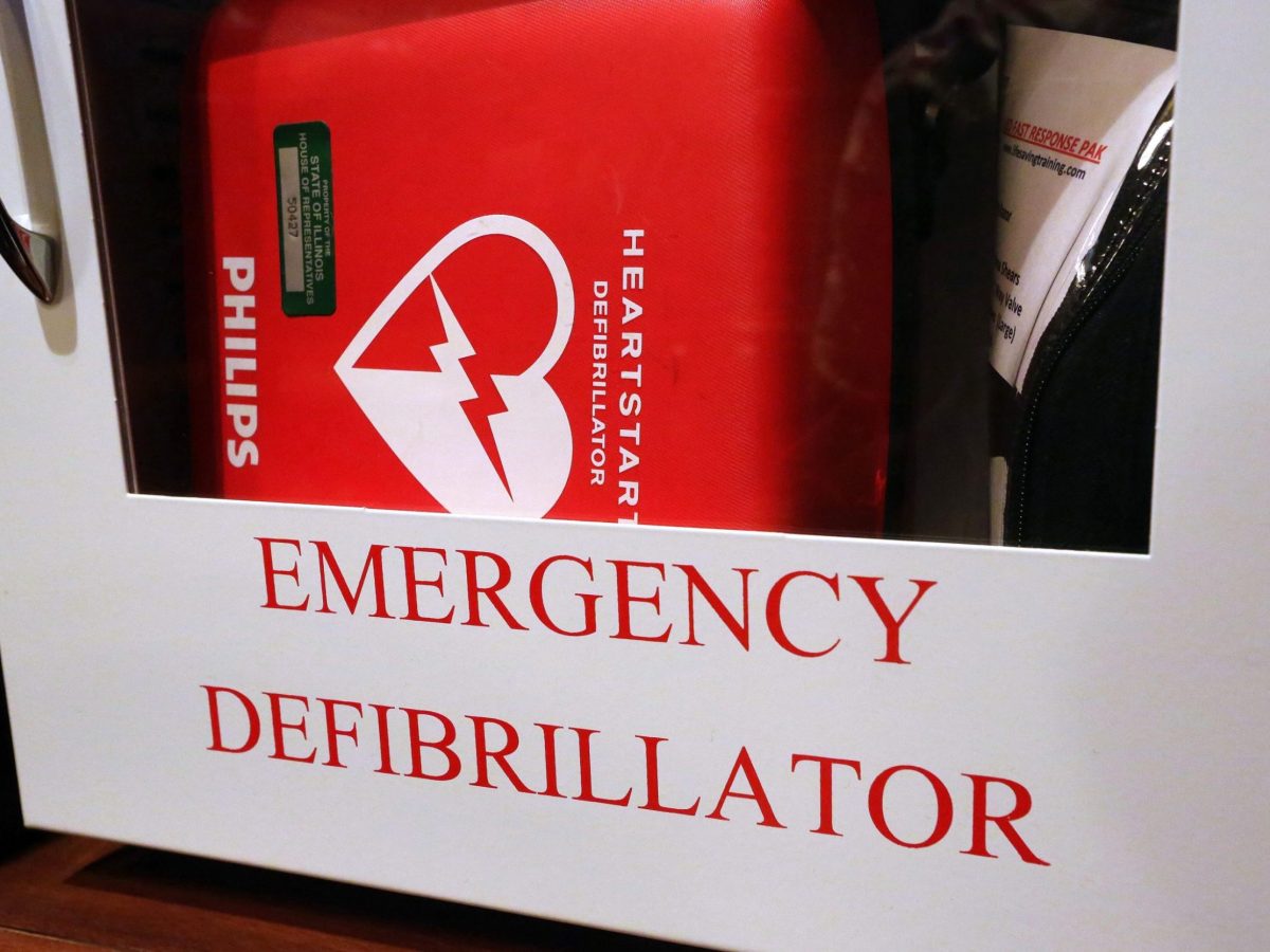 In this Tuesday, July 1, 2014 photo, an emergency defibrillator, used to treat life threatening conditions that affect the rhythm of the heart such as cardiac arrhythmia, hangs on the wall at the Illinois State Capitol Tuesday, July 1, 2014, in Springfield, Ill. A new Illinois law prompted by the death of a high school student during dance practice requires students learn CPR and how to operate Automated External Defibrillators machines used to treat emergency heart problems. (AP Photo/Seth Perlman)