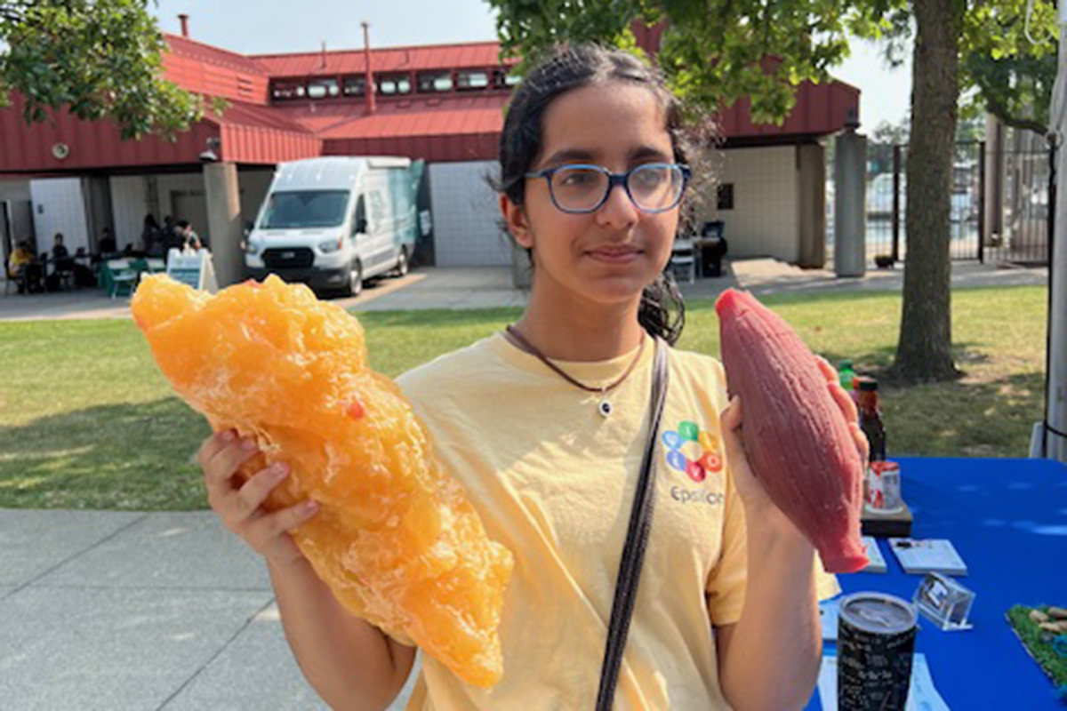 Simran Adnani hold an ear of corn and a blob of fat.