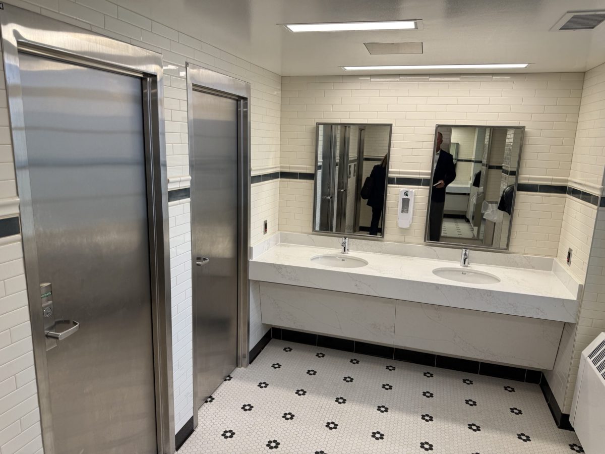 A bathroom with two stalls in a college dorm
