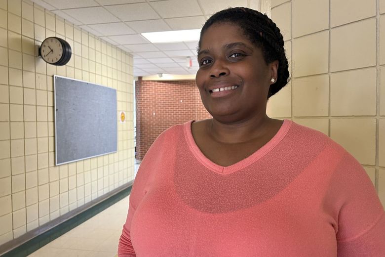 Parent and teacher’s aide Natasha Bennett-William poses for a picture in the hallway.