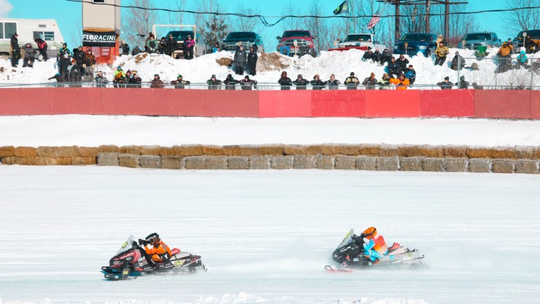 Snowmobilers race in an arena