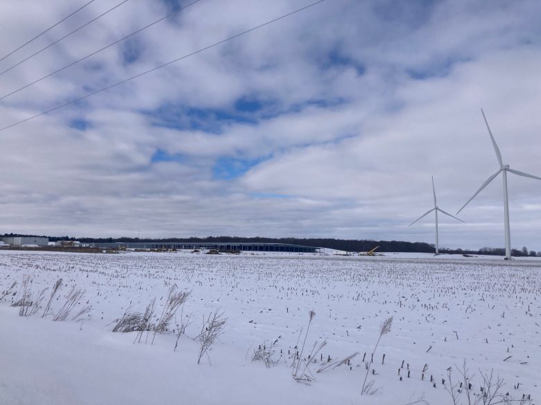 Snowy land in front of wind turbines. 