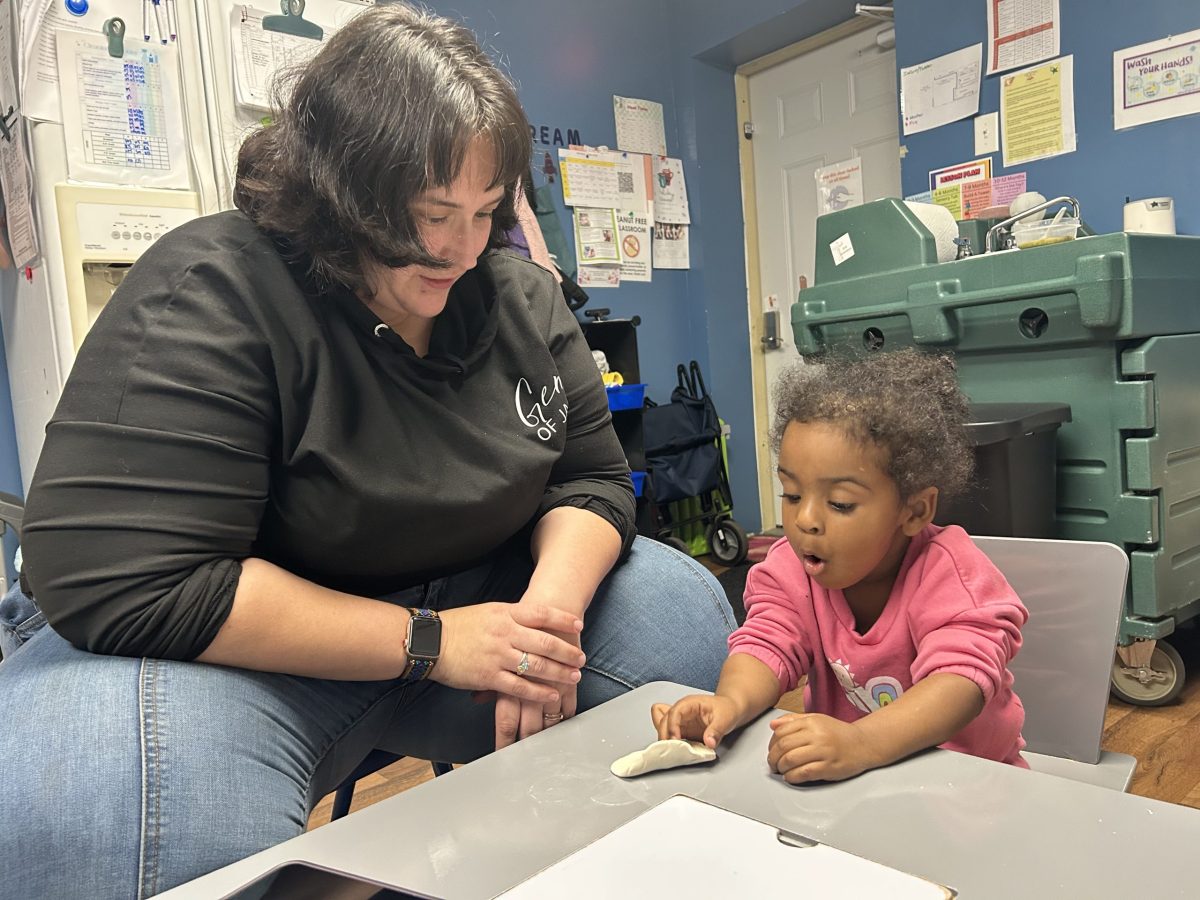 Woman sits at a table with a young child