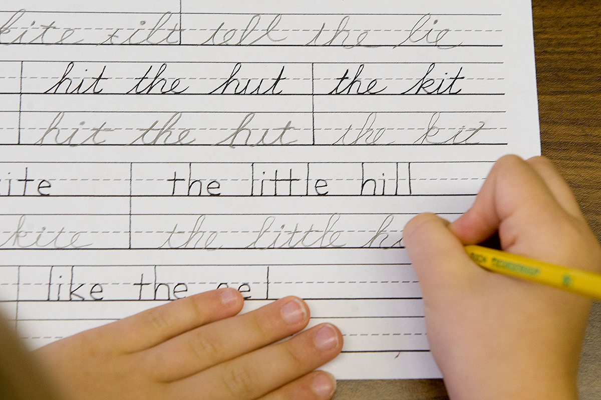 A child practicing cursive. 