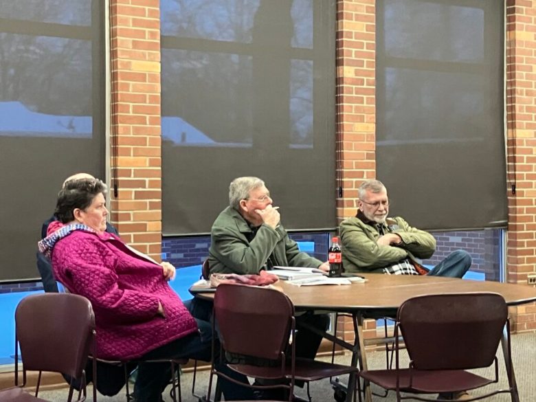 Dennis Kellogg and other at a table. 