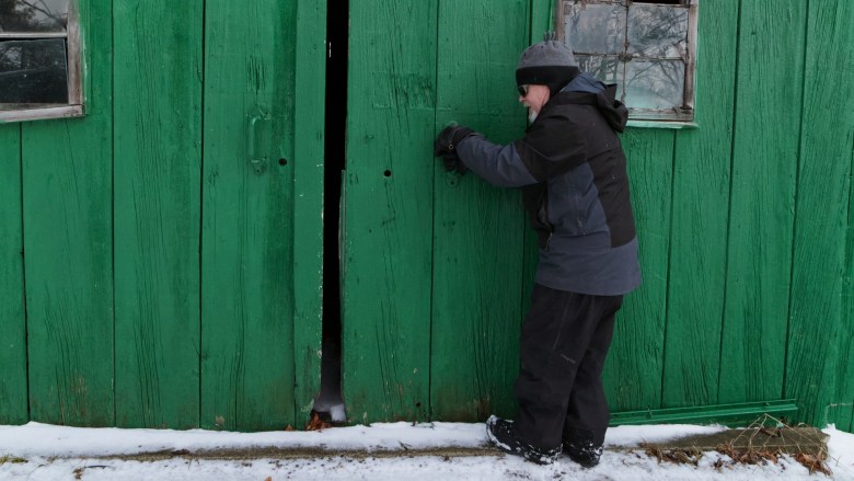 A man opens a barn door