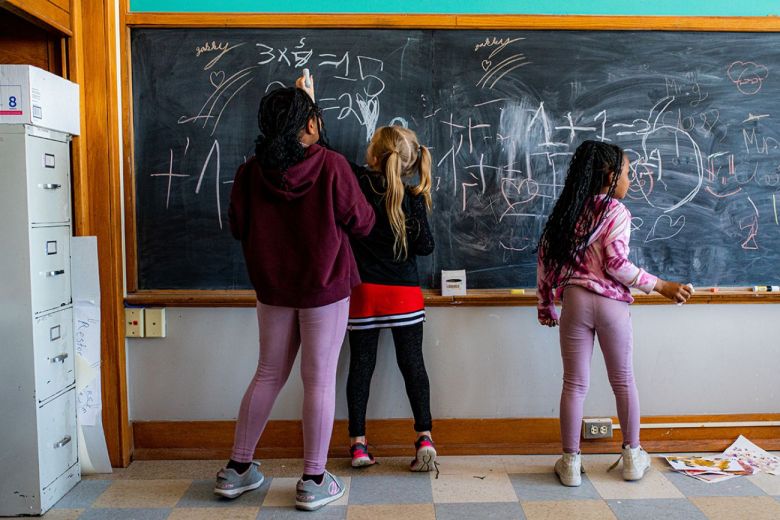 Children writing on a chalkboard. 