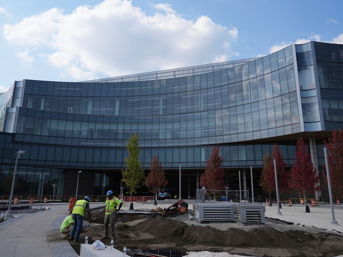 Two workers in hard hats can be seen in front of the future Ford World Headquarters. 