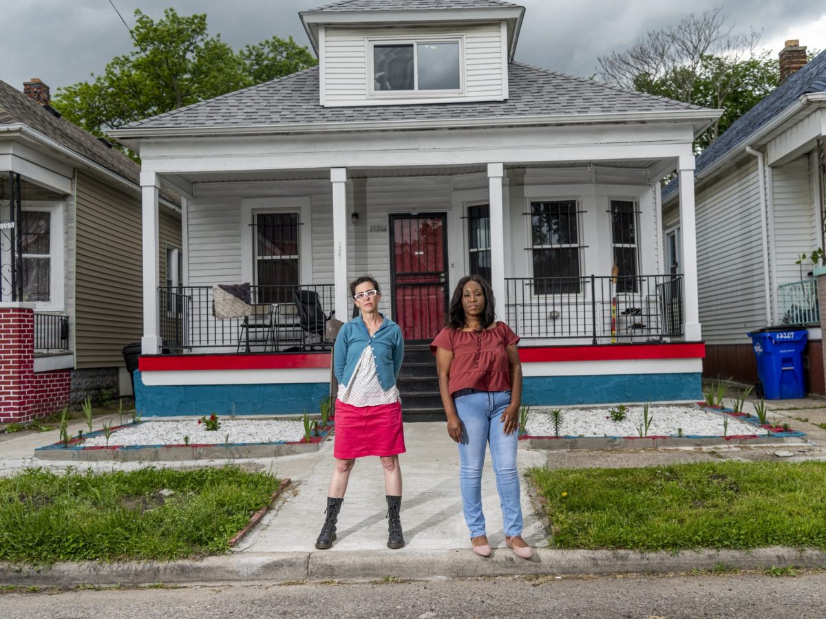 two woman in front of a house