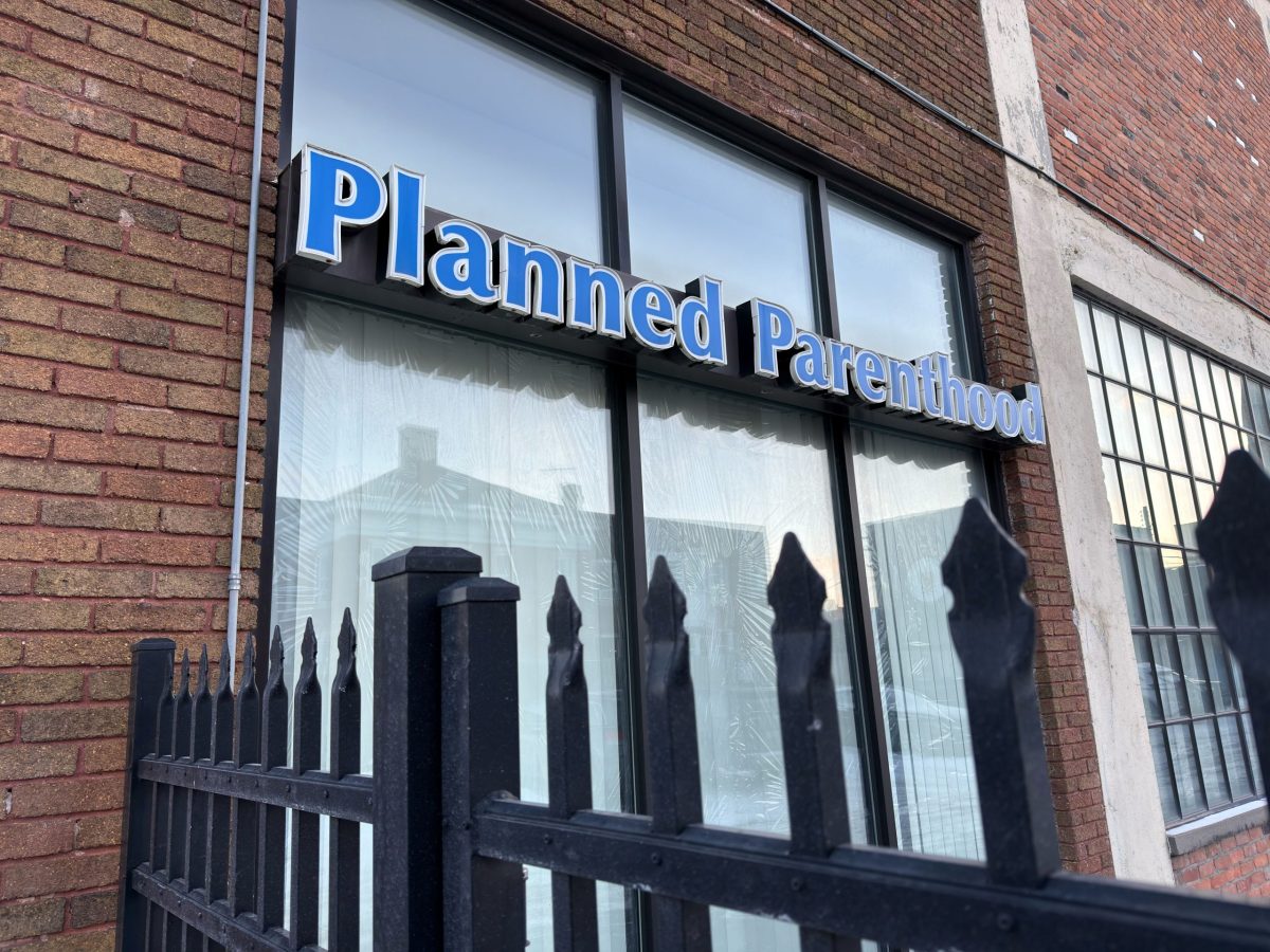 Exterior of a Planned Parenthood health center, surrounded by a wrought iron fence.