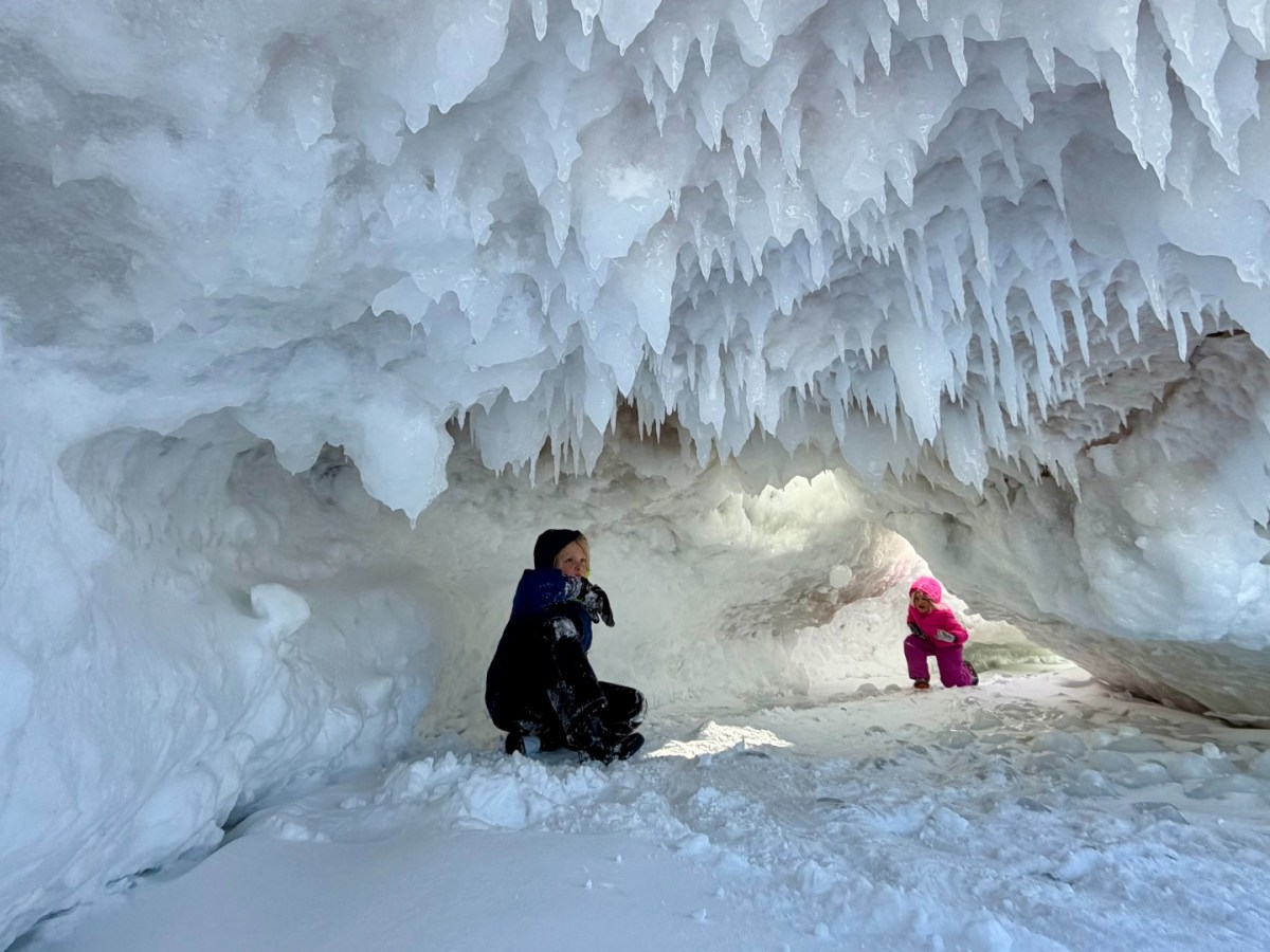 A mother and a daughter play in an ice cave