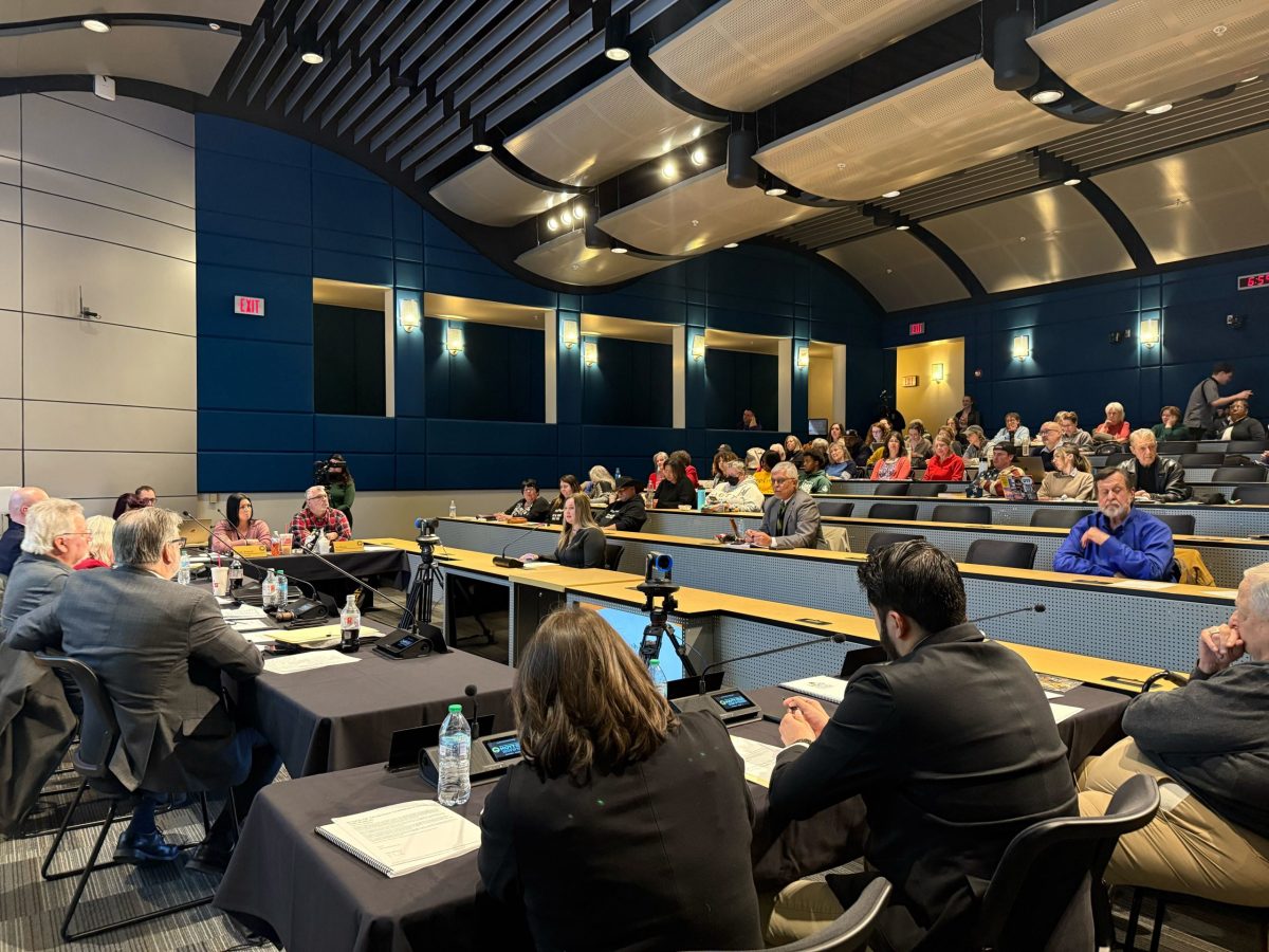 people seated at tables at a board meeting