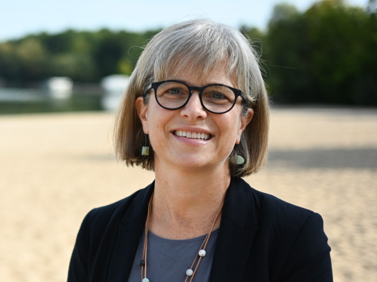 Headshot of smiling woman with sand and in the background