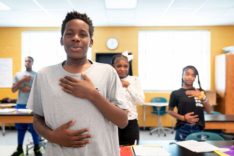 Students putting their hands on their chest.