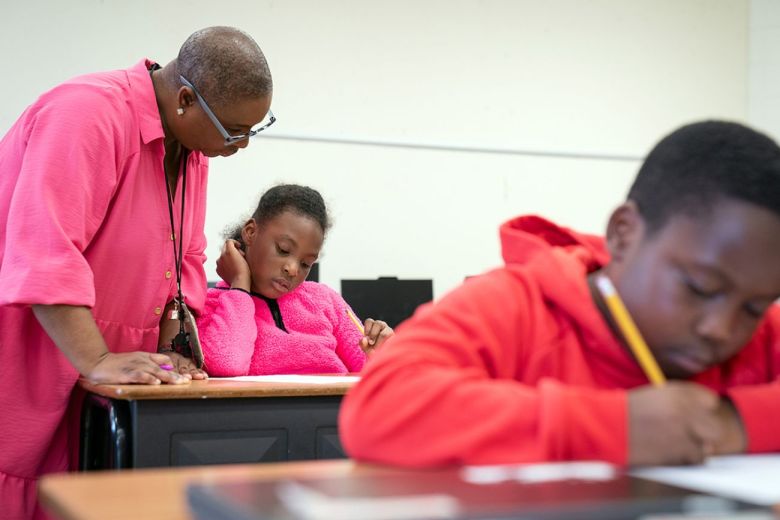 A teacher helps a student.