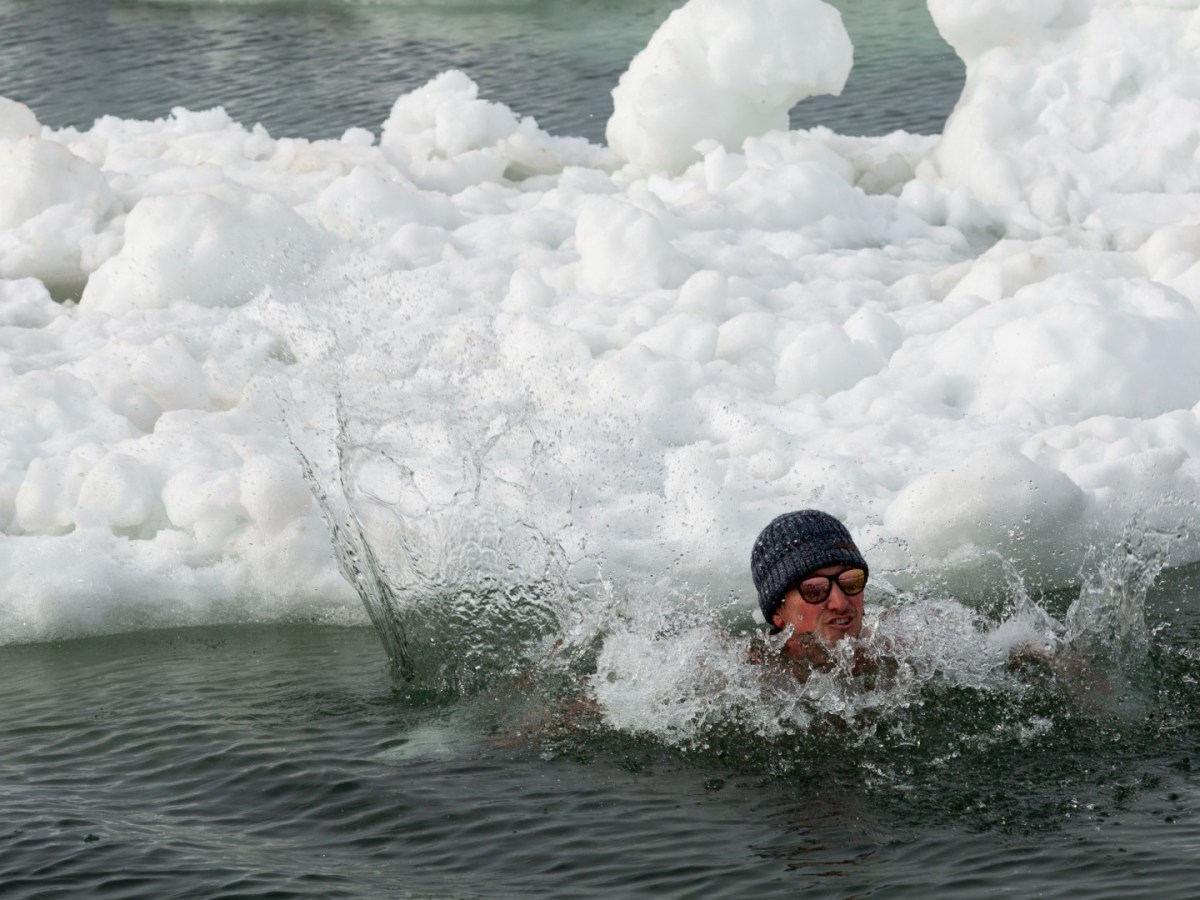 A man swims in icy waters
