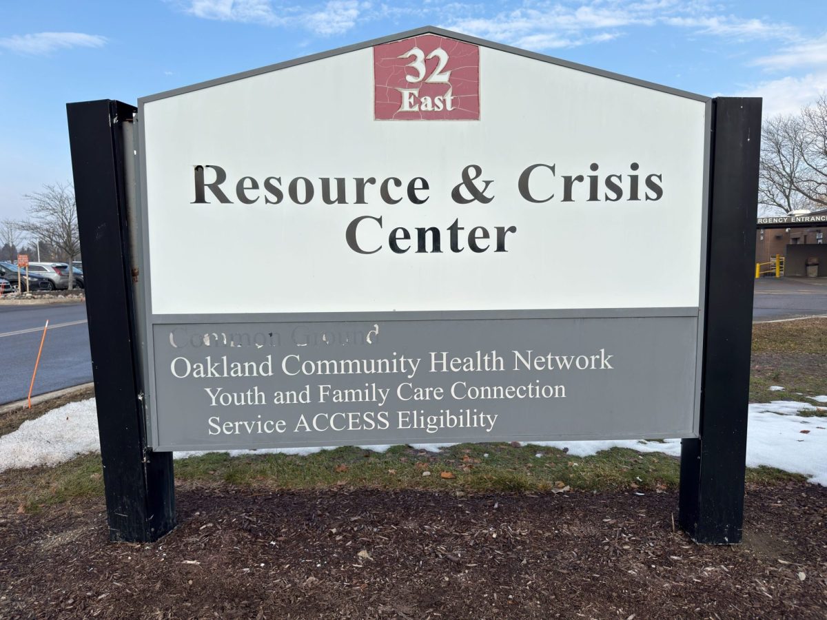 close up of a sign for Resource & Crisis Center showing old name faded out.