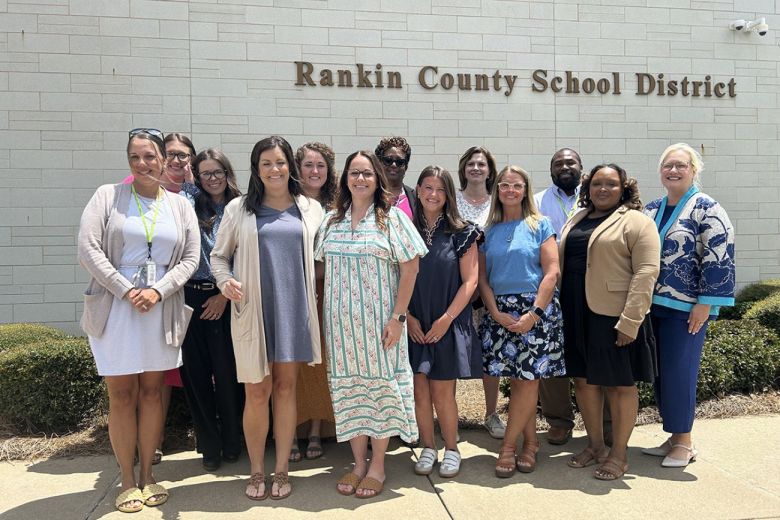 People posing for a group photo in front of a building for the Rankin County School District.