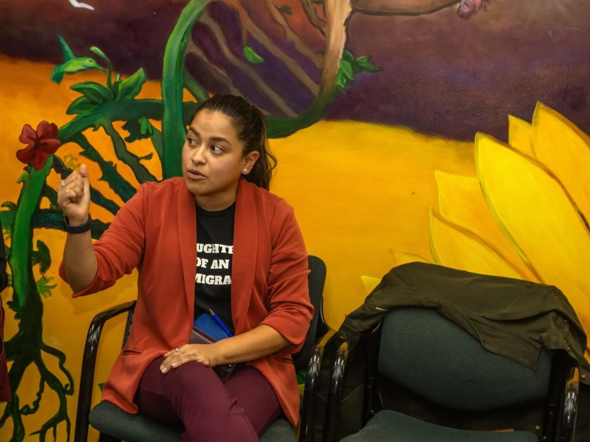 Detroit City Council Member Gabriela Santiago-Romero sitting in front of a mural