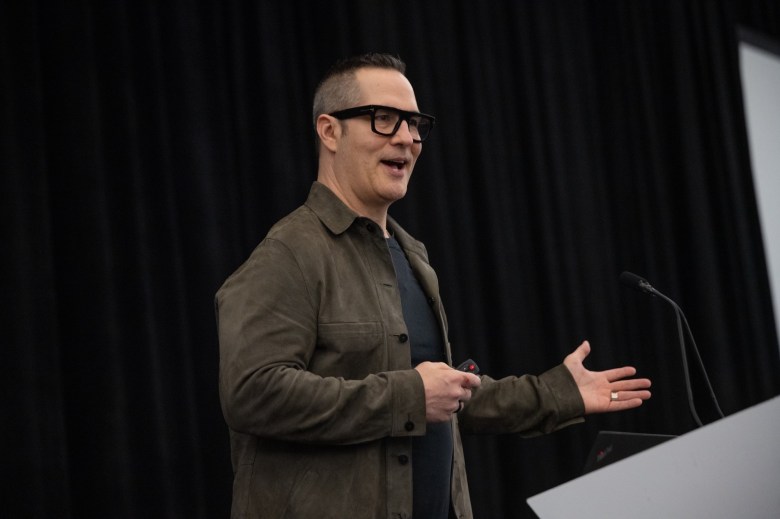 Side view of a man gesturing while speaking 