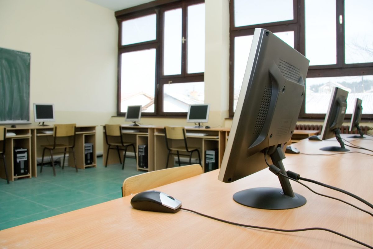 empty classroom with computer monitors on tables