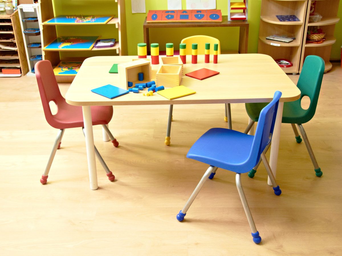 stock photo of an empty kindergarten classroom desk with colorful chairs and blocks to play with