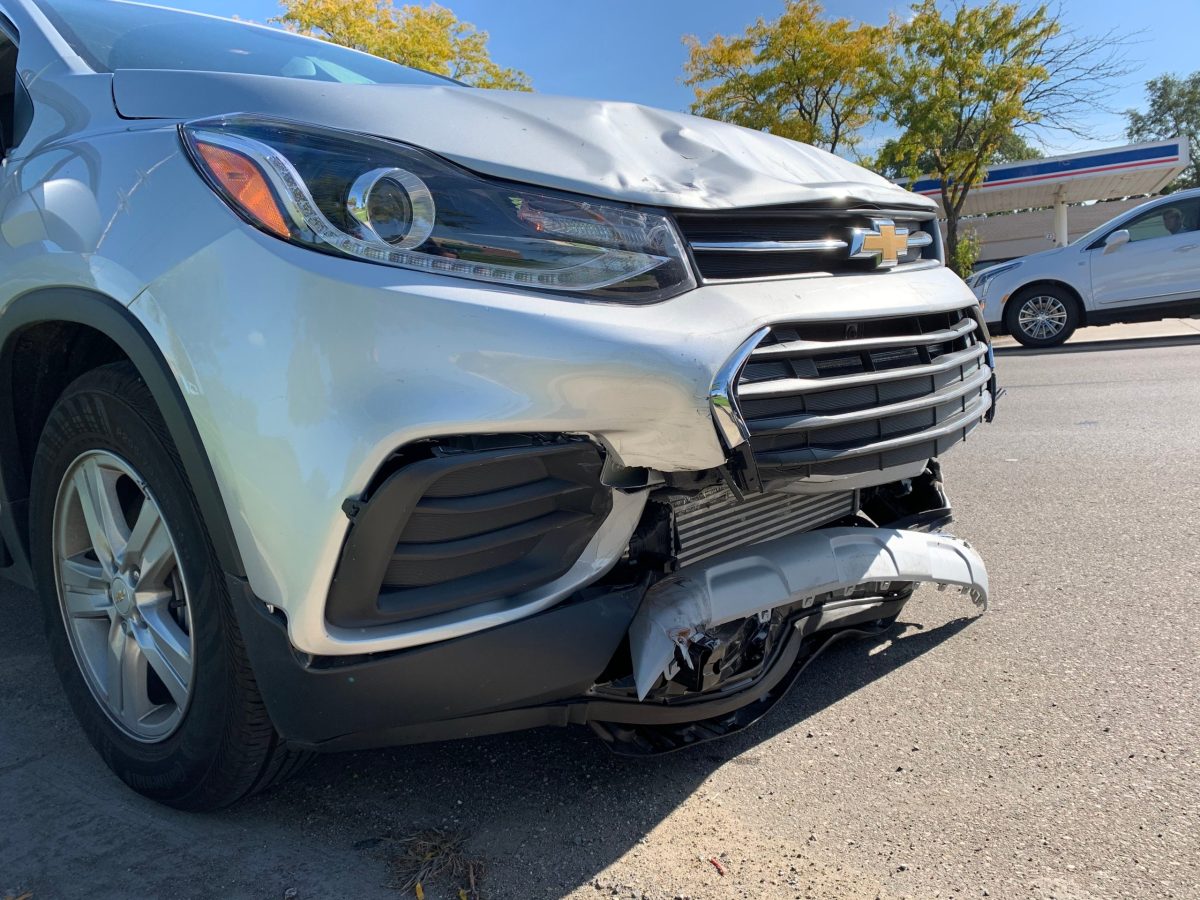 Damaged front end of a silver Chevrolet car after an accident.