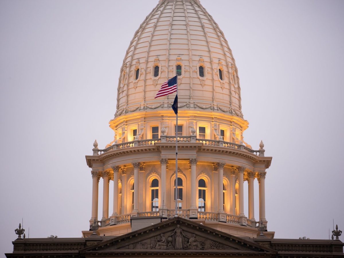 Michigan Capitol dome illuminated with American flag flying in front
