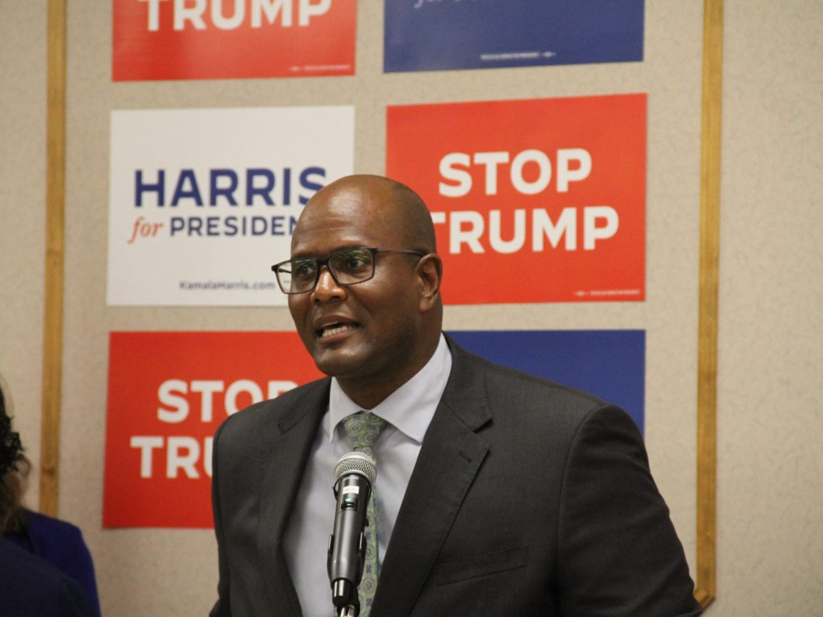 Detroit House Speaker Joe Tate into microphone; Harris signs behind him
