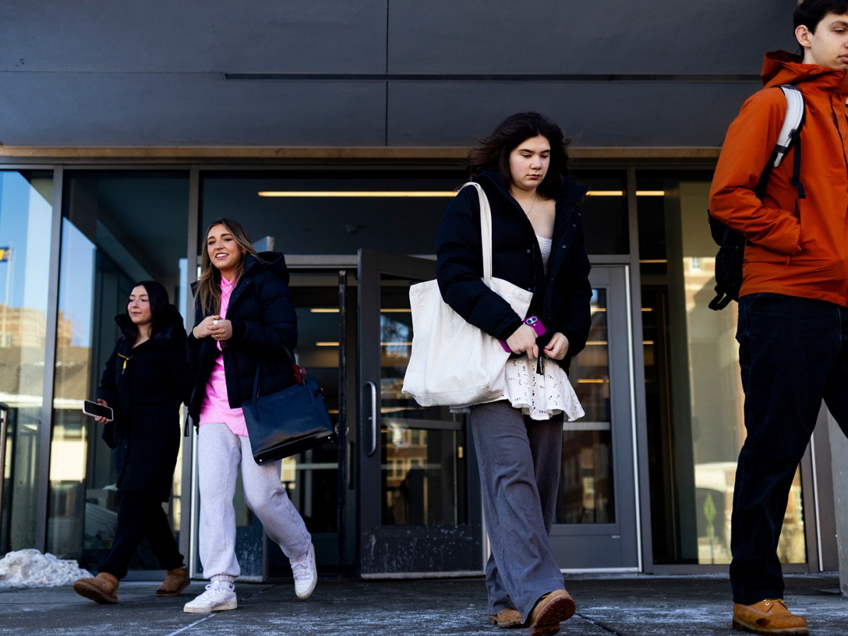 College students walking outside a building.
