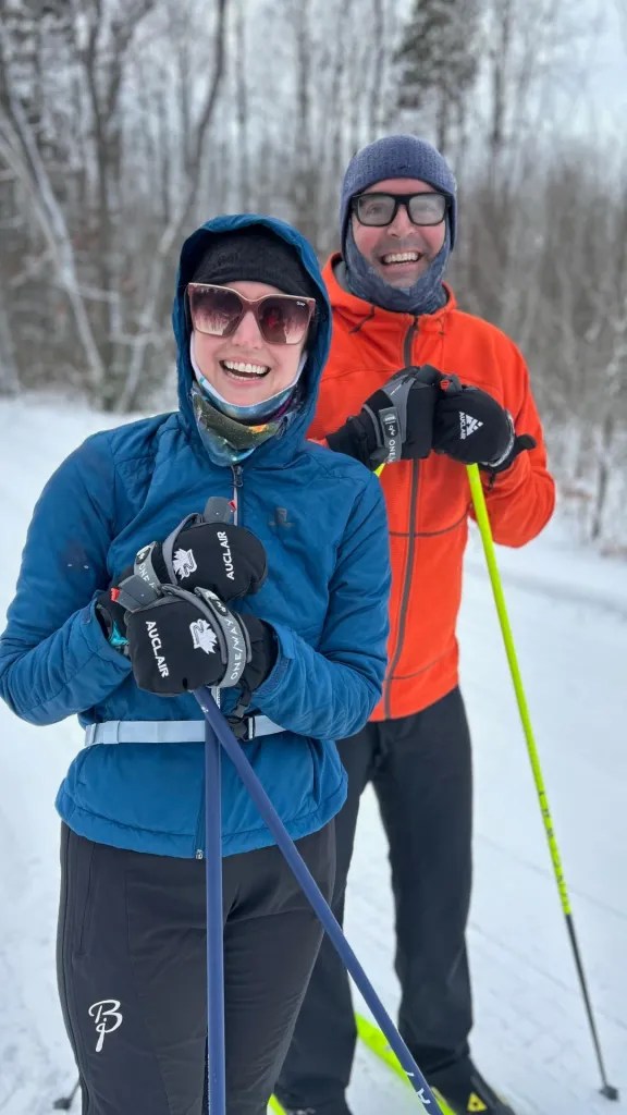 Two people stand on cross-country skis in the snow