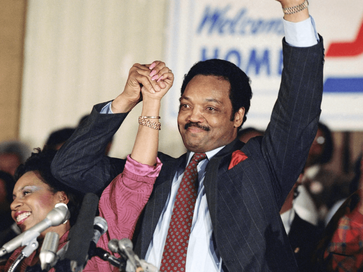 Democratic presidential hopeful Jesse Jackson with his wife, Jacqueline, salutes the cheering crowd at Operation Push in Chicago, March 10, 1988.